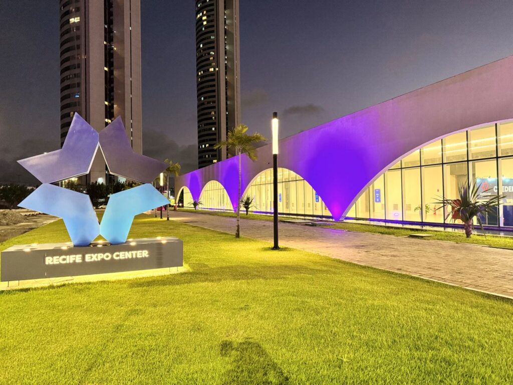Foto da fachada do Recife Expo Center iluminada de roxo em prol da campanha de conscientização sobre o Alzheimer.